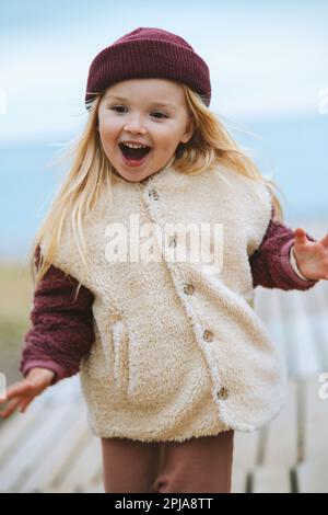 Bambino che cammina all'aperto ragazza che indossa morbido sherpa giacca moda vestito inverno elegante abbigliamento 4 anni bambino famiglia stile di vita emotivo viso bambino Foto Stock