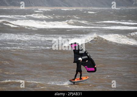 Un surfista alare scivola attraverso un mare mosso alimentato da una brezza rigida al largo della costa Jurrasic nella baia di Lyme. Dorset.UK Foto Stock