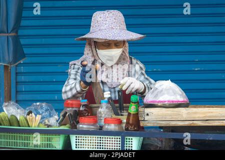 SAMUT PRAKAN, THAILANDIA, 21 2023 GENNAIO, Un venditore di strada prepara insalata di papaya per i clienti Foto Stock