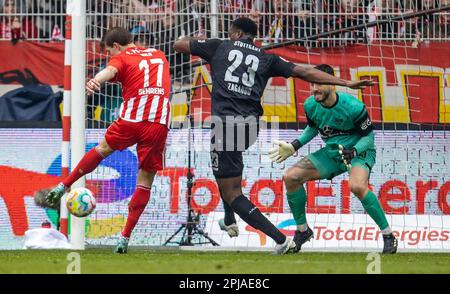 01 aprile 2023, Berlino: Calcio, Bundesliga, 1. FC Union Berlin - VfB Stuttgart, giorno 26, an der Alten Försterei. Il berlinese Kevin Behrens (l) vince il portiere Fabian Bredlow (r) di VfB Stuttgart e segna per arrivare a 2:0. Il Dan-Axel Zagadou di Stoccarda non può impedire l'obiettivo. Foto: Andreas Gora/dpa - NOTA IMPORTANTE: Conformemente ai requisiti della DFL Deutsche Fußball Liga e della DFB Deutscher Fußball-Bund, è vietato utilizzare o utilizzare fotografie scattate nello stadio e/o della partita sotto forma di sequenze di immagini e/o serie di foto simili a un video. Foto Stock