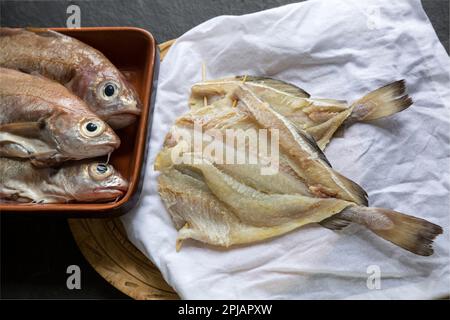 Busting in casa salato ed essiccato, Trisopterus luscus, che sarà usato per preparare il piatto noto come brandade. Una busta fresca può essere vista sulla sinistra ogf il Foto Stock