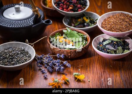 Assortimento di medicinali a base di erbe e tè di frutta in ciotole Foto Stock