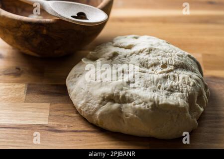 Lievito fresco la pasta per pane e pizza e baguette su sfondo di legno Foto Stock