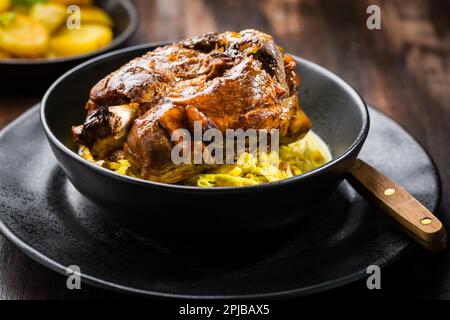 Girarrosto fuso a snodo di maiale con verze e patate al forno - cucina tradizionale tedesca, Eisbein, Schweinehax Foto Stock