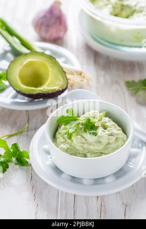 Delizioso avocado spalmato con formaggio cagliato e ingredienti. Concetto di cibo heathy Foto Stock