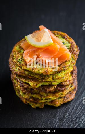 Frittelle di zucchine fatte in casa con salmone affumicato e limone. Concetto di cibo sano Foto Stock