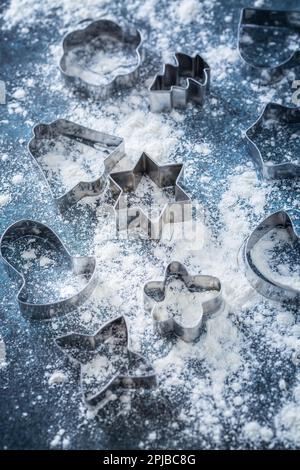 Cottura di Natale - biscottini e farina su sfondo scuro. Panetteria fatta in casa, dolce natalizio, concetto di vacanza invernale Foto Stock