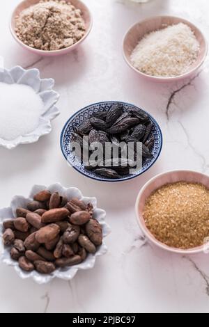 Assortimento di ingredienti da forno flagranti, tonka e fagioli di cacao, farina di mandorle e cocco su fondo di legno bianco Foto Stock