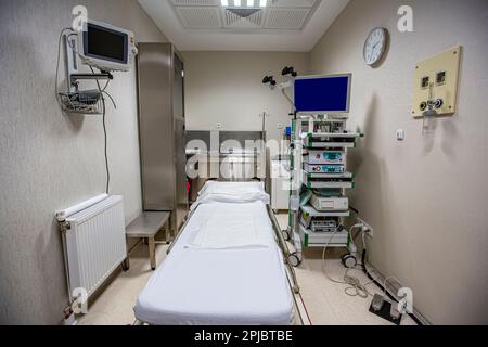 Moderno kit di apparecchiature per endoscopia. Sistema di endoscopia video elettronica. Un lettino per i pazienti e un supporto con un gastroscopio e un monitor. Foto Stock