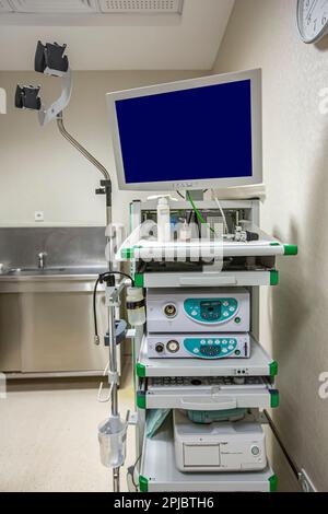 Moderno kit di apparecchiature per endoscopia. Sistema di endoscopia video elettronica. Un lettino per i pazienti e un supporto con un gastroscopio e un monitor. Foto Stock