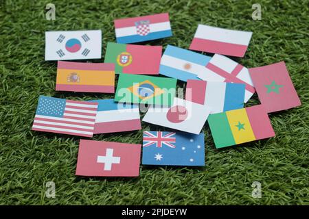 Pallone da calcio in pelle con bandiere internazionali dei paesi partecipanti al torneo isolato su sfondo bianco. Calcio Foto Stock