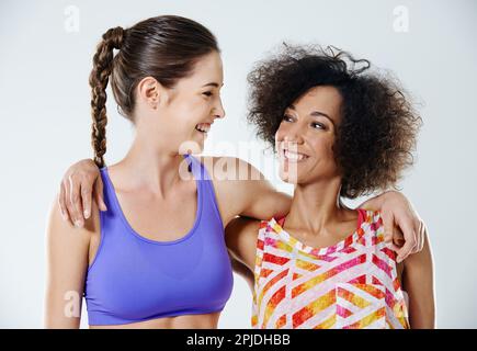 Partner in fitness. Due giovani donne che si guardano mentre indossano abiti sportivi. Foto Stock