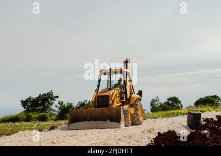 Pala frontale con pala spandiconcime su Una carreggiata Foto Stock