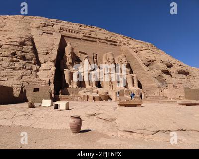 Un gruppo di turisti di fronte alle massicce statue di pietra dei templi di Abu Simbel. Egitto. Foto Stock