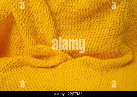 Coperta arancione uncinetto, sfondo astratto, messa a fuoco morbida primo piano Foto Stock