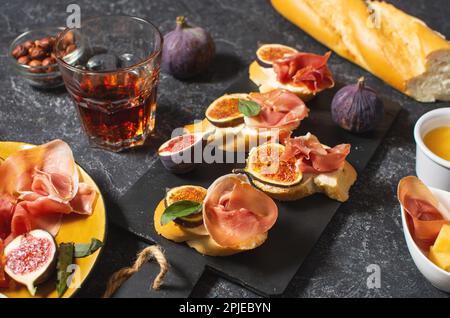Antipasti con tradizionale set di tapas spagnole. Bruschetta all'italiana con prosciutto, formaggio spalmabile e fico. Foto Stock