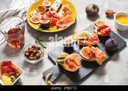 Antipasti con tradizionale set di tapas spagnole. Bruschetta all'italiana con prosciutto, formaggio spalmabile e fico Foto Stock