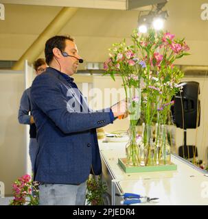 Fiorista uomo che organizza bouquet di fiori su un palco, maestro di floricoltura classe. Aprile 17, 2019. Mostra Fiore Expo. Kiev, Ucraina Foto Stock