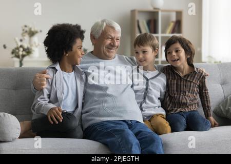 Allegri nonni multietnici e nonno che riposano sul divano Foto Stock