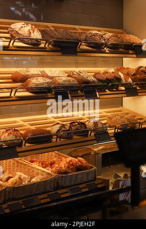 Stand con cibo al forno. Panetteria all'interno. Mensole con pane Foto Stock