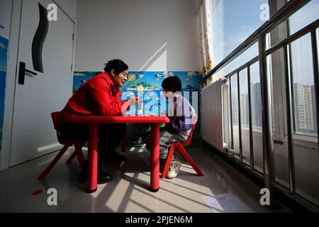 (230402) -- XINING, 2 aprile 2023 (Xinhua) -- Chen Zhifang (L) presenta un addestramento di riabilitazione per un bambino autistico al Centro di Servizio speciale per Bambini Starlight a Xining, nella provincia di Qinghai della Cina nord-occidentale, 30 marzo 2023. Chen Zhifang è il fondatore del centro speciale di servizio per bambini Starlight di Xining. Fondato nel 2015, il centro di servizi è un'organizzazione pubblica senza scopo di lucro che fornisce formazione e intervento di riabilitazione precoce per bambini con autismo, disabilità intellettuali e disturbi linguistici. Attualmente, 132 bambini autistici stanno ricevendo varie riabilitatio Foto Stock