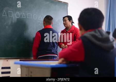 (230402) -- XINING, 2 aprile 2023 (Xinhua) -- Chen Zhifang (C) presenta la formazione cognitiva per un bambino autistico al Centro di Servizio Speciale per Bambini Starlight a Xining, nella provincia di Qinghai della Cina nord-occidentale, 30 marzo 2023. Chen Zhifang è il fondatore del centro speciale di servizio per bambini Starlight di Xining. Fondato nel 2015, il centro di servizi è un'organizzazione pubblica senza scopo di lucro che fornisce formazione e intervento di riabilitazione precoce per bambini con autismo, disabilità intellettuali e disturbi linguistici. Attualmente, 132 bambini autistici stanno ricevendo varie riabilitazione tra Foto Stock