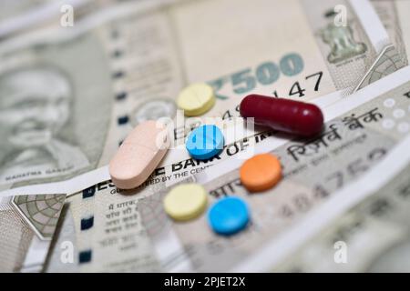 Pillole mediche e compresse con banconote in valuta indiana Foto Stock