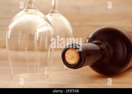 Bottiglia di vino in vetro, due bicchieri e un cavatappi su fondo ligneo. Foto Stock