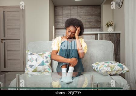 Ritratto di una donna nera afro-americana. Depressione, mal di testa, solitudine dopo una rottura, malattia mentale, stress sul lavoro, anelito, tristezza. separ Foto Stock