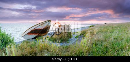 Barca a remi su scivolo con meccanismo di sollevamento lungo la diga Del Ijsselmeer con le nuvole di pioggia di colore rosso che scivola sopra il lago Foto Stock