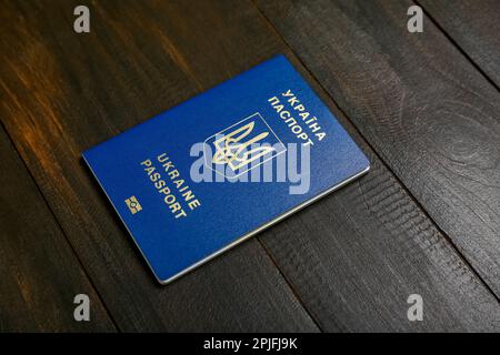 Passaporto ucraino su sfondo di legno nero Foto Stock