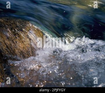 Giappone. Primo piano di flusso veloce-fluente su massi. Foto Stock