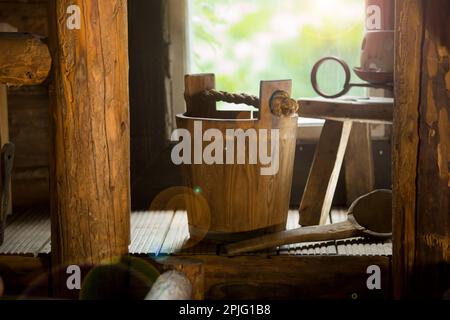 Sauna finlandese tradizionale in legno nei dettagli. Secchio in legno con paletta. Vecchio interno rustico. Foto Stock