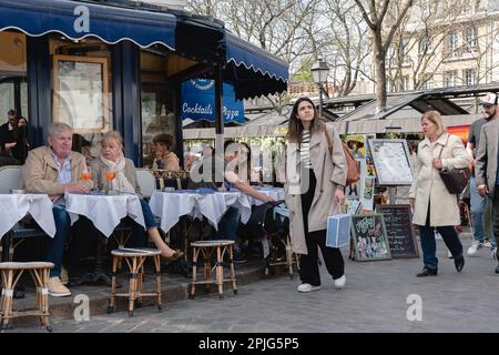 Turisti e visitatori seduti nei ristoranti intorno alla Place du Tertre e guardare i pittori. Foto Stock