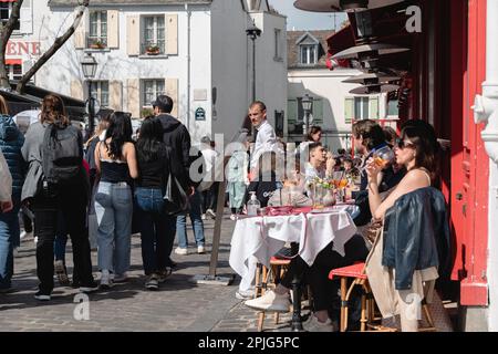 Turisti e visitatori seduti nei ristoranti intorno alla Place du Tertre e guardare i pittori. Foto Stock