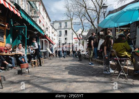 Turisti e visitatori seduti nei ristoranti intorno alla Place du Tertre e guardare i pittori. Foto Stock