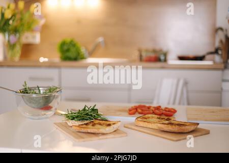 Tavolo con bruschetta in cucina. Preparare un panino vegano. Concetto di cibo fatto in casa. Nessuna gente Foto Stock