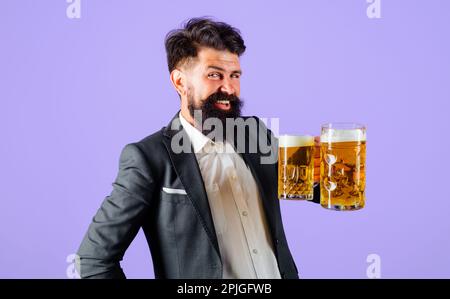 Sorridente uomo bearded con tazza di birra artigianale. Alcool. Birra in Germania. Birra artigianale al ristorante. Tempo di birra. Uomo d'affari in tuta degustazione fresco delizioso Foto Stock