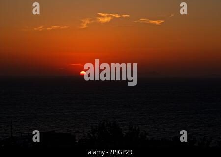 Il sole che tramonta come si vede da Oia, Santorini, Grecia Foto Stock