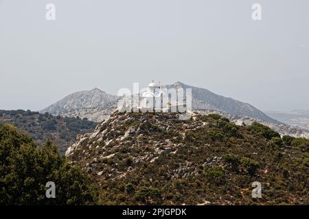 Una piccola cappella bianca sulla cima di una collina nell'isola di Naxos, Grecia Foto Stock