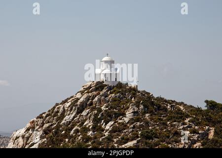 Una piccola cappella bianca sulla cima di una collina nell'isola di Naxos, Grecia Foto Stock