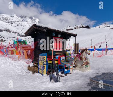 Scenario innevato con capanna in legno con finestra rossa in un'area giochi per bambini nella località sciistica di Breuil-Cervinia in Valle d'Aosta Foto Stock