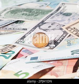 Una moneta color oro con una denominazione di 10 rubli russi si trova in cima agli Stati Uniti e alla carta moneta europea di diverse denominazioni - USD, EUR Vista f Foto Stock