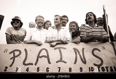 Carter e Mondale con i membri della squadra di softball dei corpi di stampa della Casa Bianca, soprannominati The News Twisters, presso il campo di baseball della Plains High School. Il team di carter era composto principalmente da agenti del Servizio Segreto USA fuori servizio. Un osservatore ha paragonato il Servizio Segreto contro il gioco della stampa ai “New York Yankees contro una squadra di softball della scuola media . . . se gli studenti medi avessero bevuto tutta la notte”. Da sinistra a destra sono Justin Friedland di ABC News, Charles Mohr del New York Times, carter, James Walker di ABC News, Mondale, Rick Kaplan di CBS News, Billy carter, Curtis Wilkie del B. Foto Stock