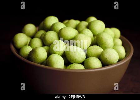 Gustose arachidi rivestite con wasabi in ciotola, primo piano Foto Stock