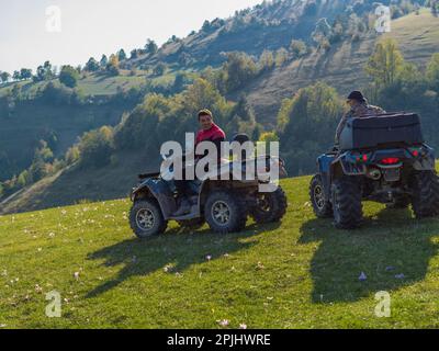 Guida avventurosa di moto ATV. Due uomini guidano una quad su strade pericolose Foto Stock