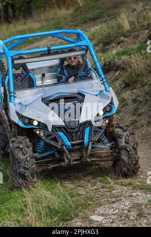 Guida avventurosa di moto ATV. Un uomo guida un quad su strade pericolose Foto Stock