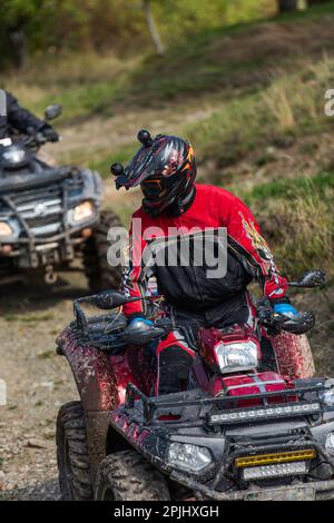 Guida avventurosa di moto ATV. Un uomo guida un quad su strade pericolose Foto Stock