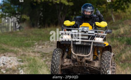 Guida avventurosa di moto ATV. Un uomo guida un quad su strade pericolose Foto Stock