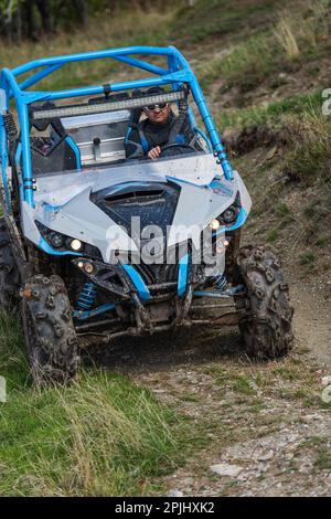 Guida avventurosa di moto ATV. Un uomo guida un quad su strade pericolose Foto Stock